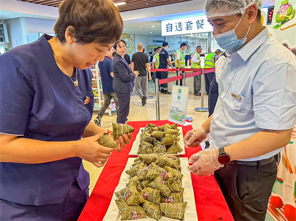 图⑧深圳机场员工在活动现场领取端午粽子.jpg